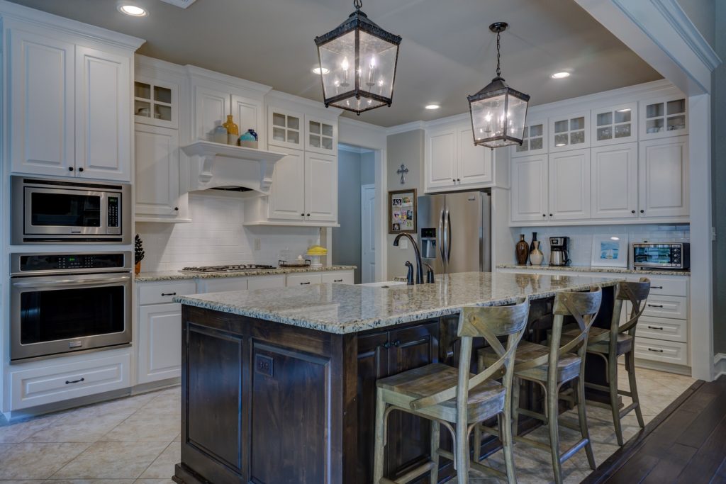 Modern kitchen with polished granite countertops and natural wood cabinets, showcasing a well-maintained space with professionally cleaned natural stone surfaces.